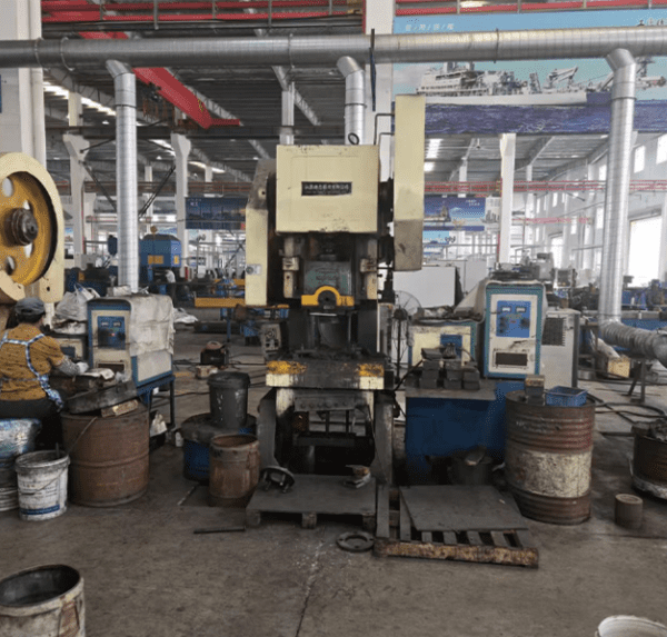 Industrial high-tonnage C-frame power press used for hot forging and stamping specialty alloy fasteners like Inconel 718, Hastelloy, and Super Duplex S32750 in a heavy-duty manufacturing facility.